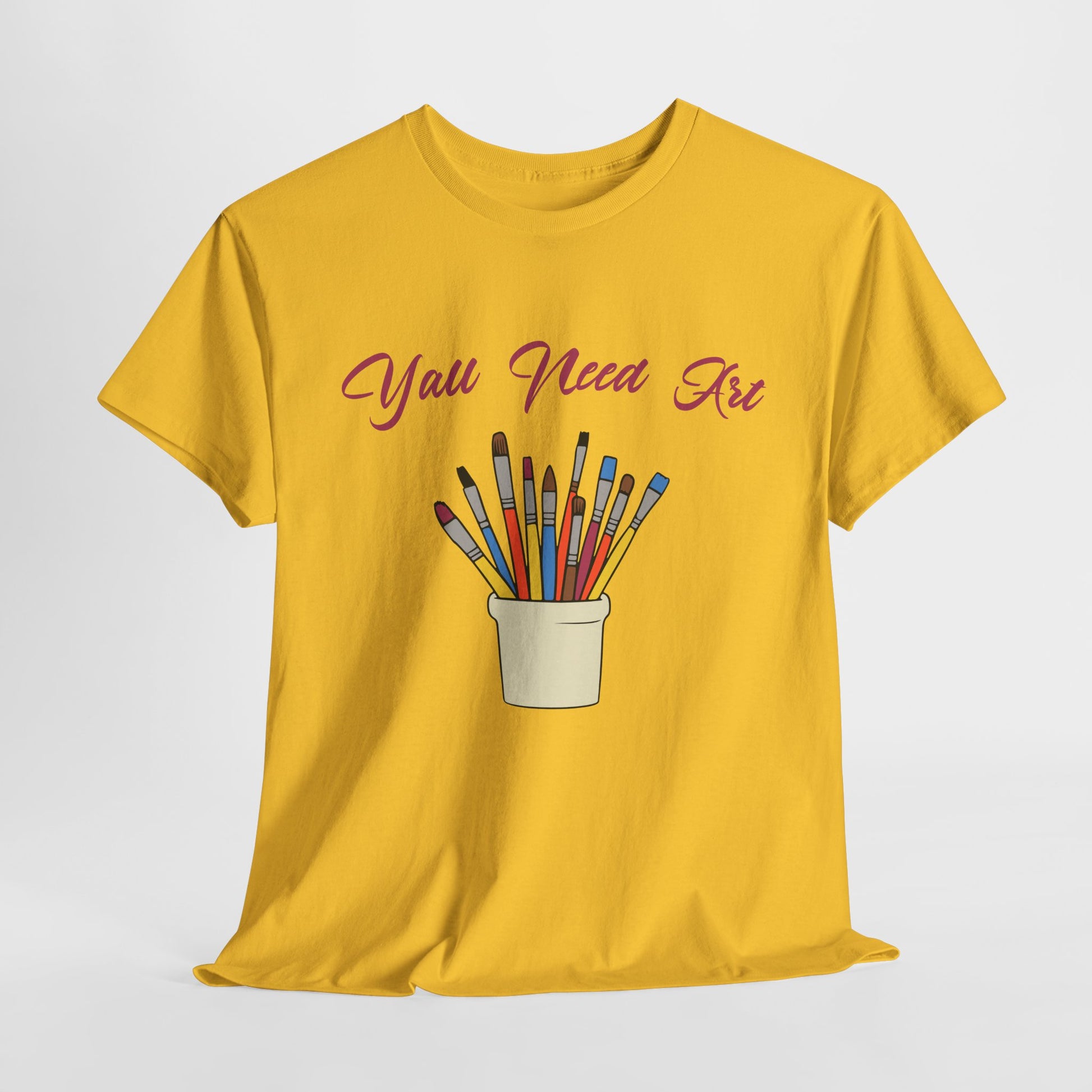 Vibrant art-themed T-shirt displayed on a flat lay with art supplies
