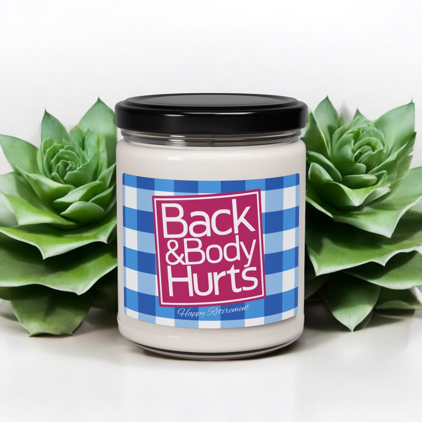 Back and Body Hurts candle in a sleek glass jar with humorous text.
